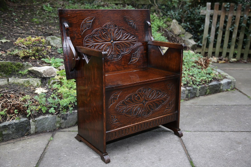 A CARVED OAK MONKS BENCH SETTLE HALL SEAT ARMCHAIR TABLE.