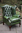 A LEATHER CHESTERFIELD ANTIQUE GREEN WING-BACK ARMCHAIR.