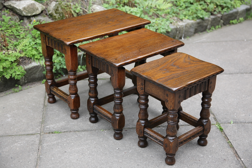 A NIGEL GRIFFITHS SOLID OAK NEST OF THREE COFFEE OCCASIONAL TABLES.
