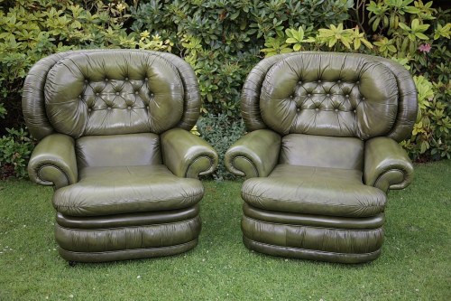 A PAIR OF CHESTERFIELD ANTIQUE GREEN LEATHER BUTTON BACK MONKS ARMCHAIRS.