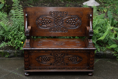 A CARVED OAK MONKS BENCH SETTLE HALL SEAT TABLE ARMCHAIR PEW CHAIR BLANKET CHEST.