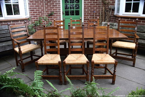 RUPERT NIGEL GRIFFITHS MONASTIC CARVED OAK DINING TABLE AND A SET OF EIGHT MATCHING DINING CHAIRS