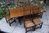 A NIGEL GRIFFITHS SOLID CARVED OAK DINING SET TABLE & SIX STICK BACK CHAIRS