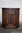 A WOOD BROTHERS OLD CHARM CARVED LIGHT OAK CANTED PEDESTAL CABINET / HALL CUPBOARD