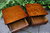 A PAIR OF WOOD BROTHERS OLD CHARM CARVED LIGHT OAK BEDSIDE TABLES / CHESTS OF DRAWERS
